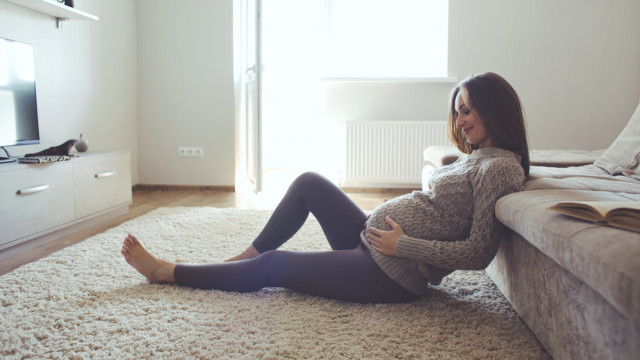 вагітна сидить на підлозі