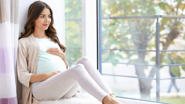 вагітна сидить на вікні