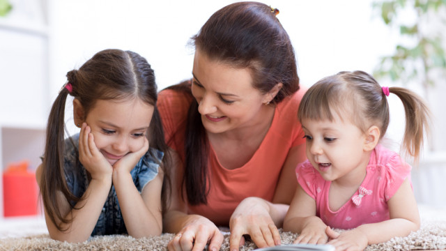 мама читает книгу с детьми