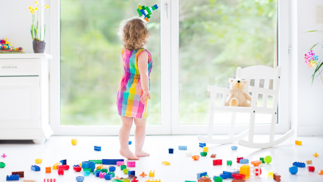 дівчинка біля вікна, багато іграшок, дитяча