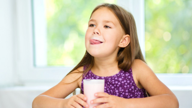 Ребенок пьет йогурт