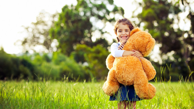 девочка обнимает медведя улыбается