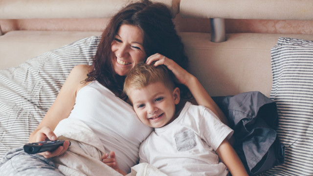 Ребенок смотрит телевизор с мамой