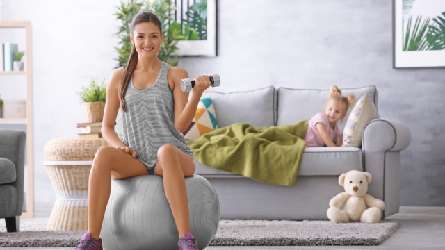 дівчина на фітболі тренується вдома