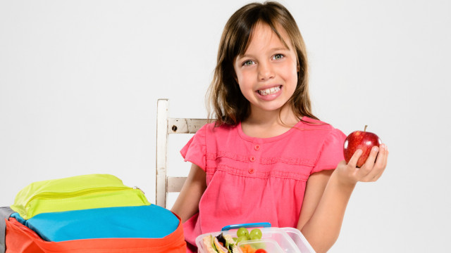 дівчинка з яблуком у школі