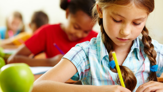 девочка в школе пишет