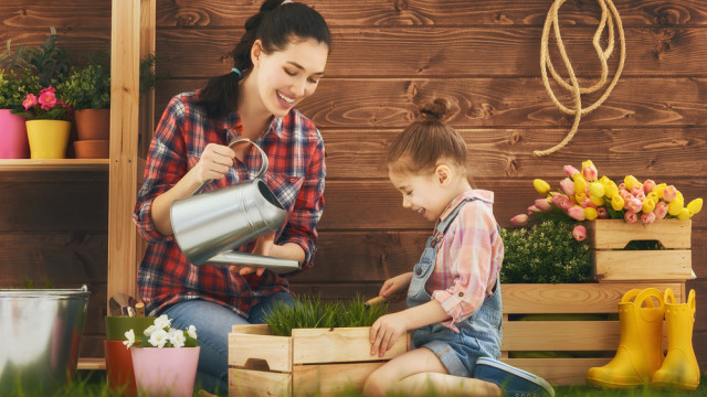 мама и дочка поливают цветы