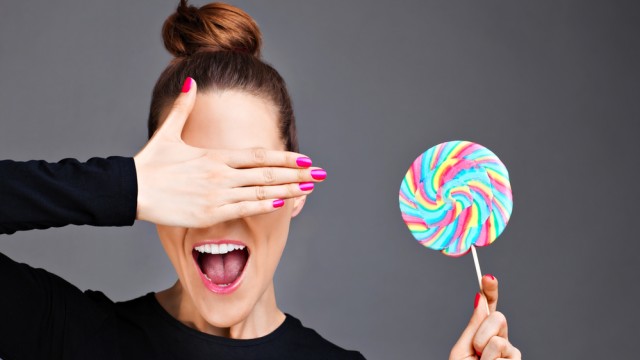 Женщина ест конфету