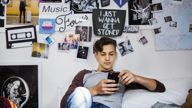 подросток смотрит в смарфон