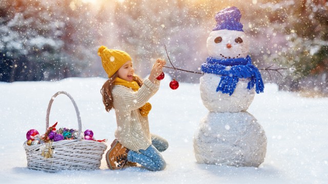 Дівчинка на вулиці зі сніговиком