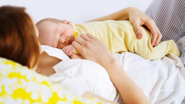 молодая мама целует младенца