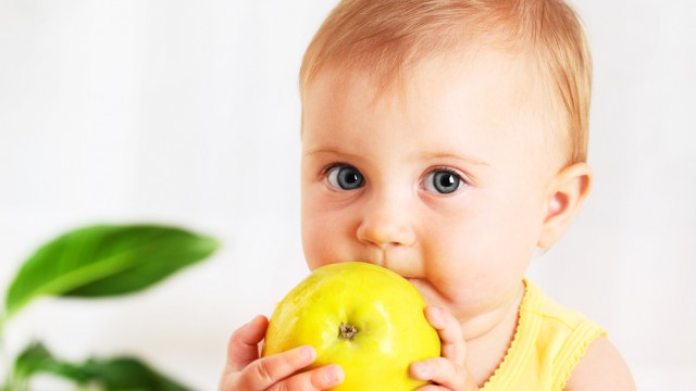 Дитина їсть яблуко